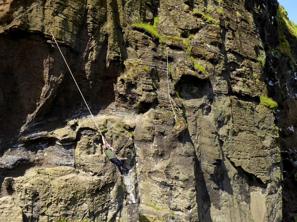 Männer üben Sprangan an den Felsen, Westmänner Inseln