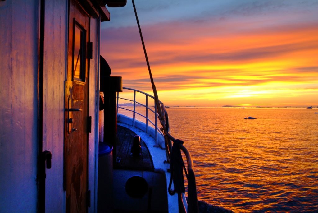 Bootsfahrt in Grönland bei Sonnenuntergang