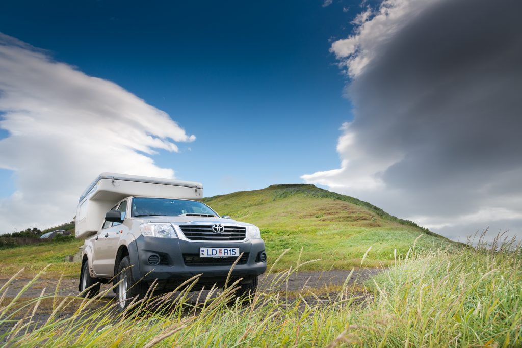 Camper in Islands Landschaft, Blauer Himmel