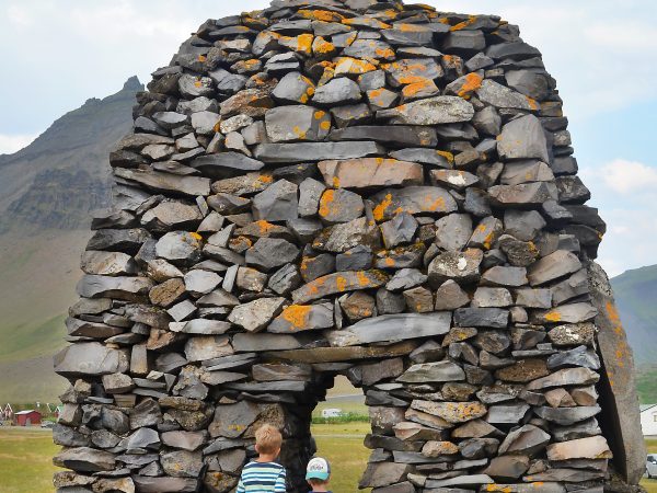 Kinder bestaunen einen Denkmal auf Snaefellsnes