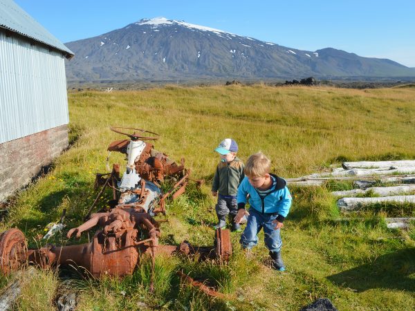 Kinder spielen und entdecken einen alten verrosteten Traktor