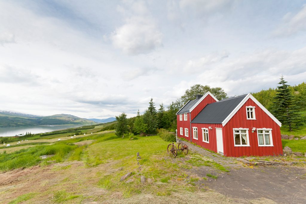 Rotes Ferienhaus mit Bäumen in Ost-Island