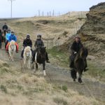 Katla Mitarbeiter reiten mit den Islandpferden durch die Frühjahrslandschaft