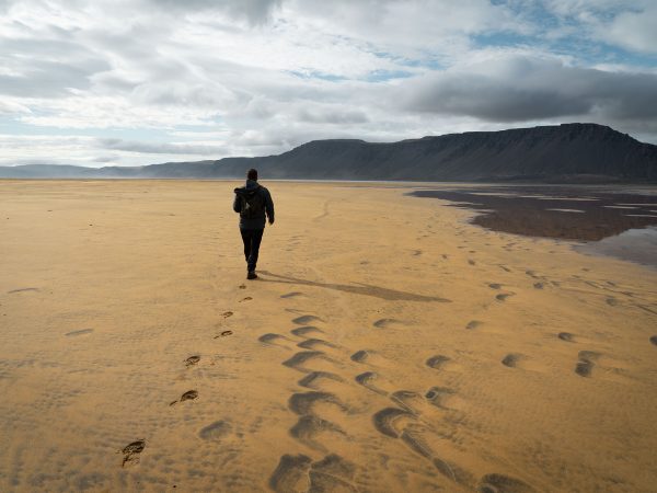 Spaziergänger am Strand von Raudisandur in den Westfjorden, Island