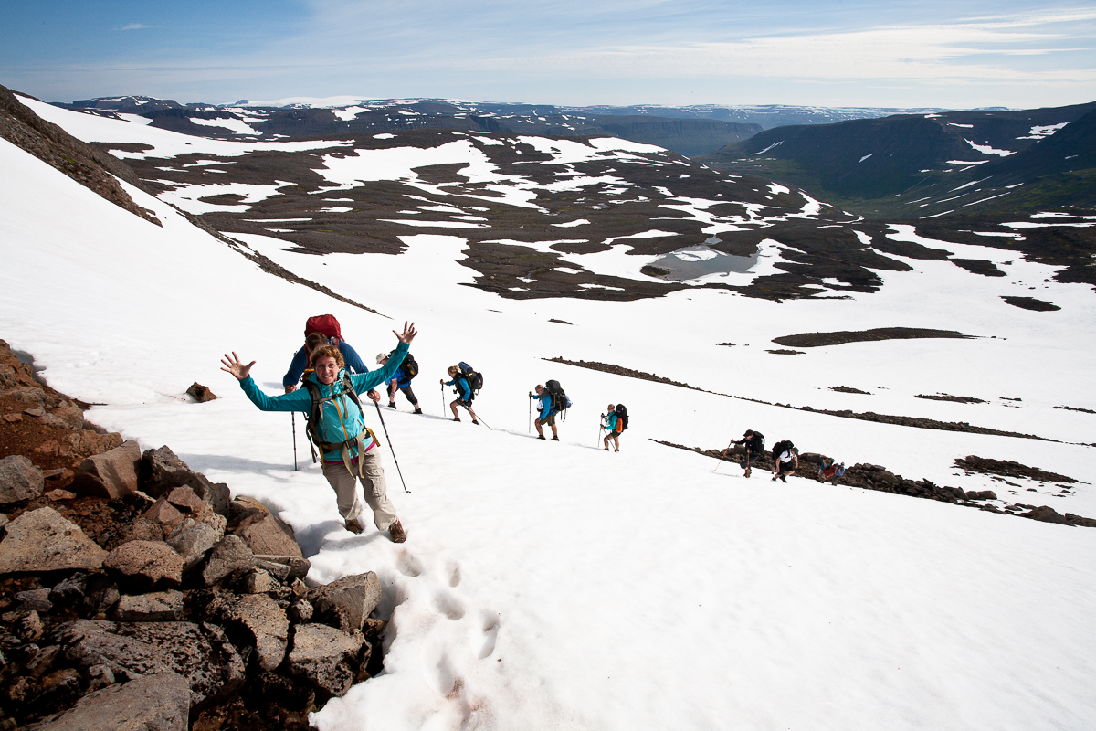 Wandergruppe läuft über ein Schneefeld in Island