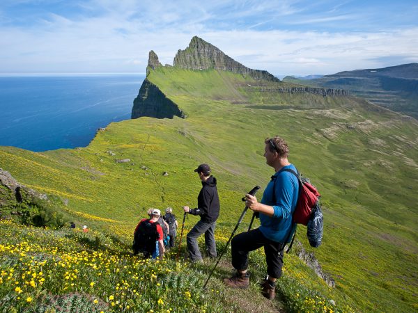 Wanderer beim Aufstieg in den Westfjorden, Hornbjarg, ein markanter Berg im Hintergrund