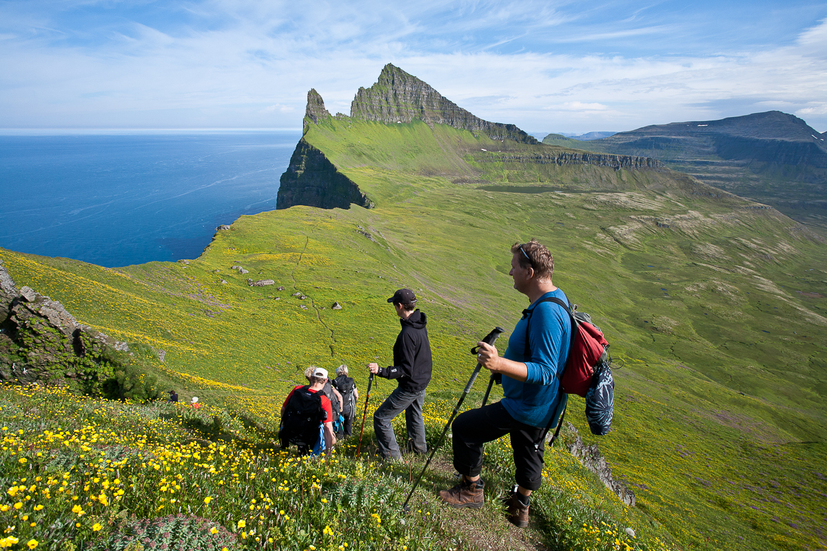 Wanderer beim Aufstieg in den Westfjorden, Hornbjarg, ein markanter Berg im Hintergrund